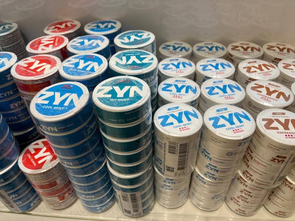 Latas de sachês de nicotina Zyn de vários sabores empilhadas em prateleira de loja nos EUA