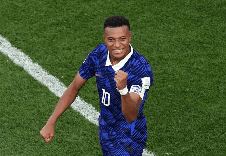 Jogador da seleção da França, de camisa azul com o número 10, comemora com o punho cerrado em campo durante partida da Copa