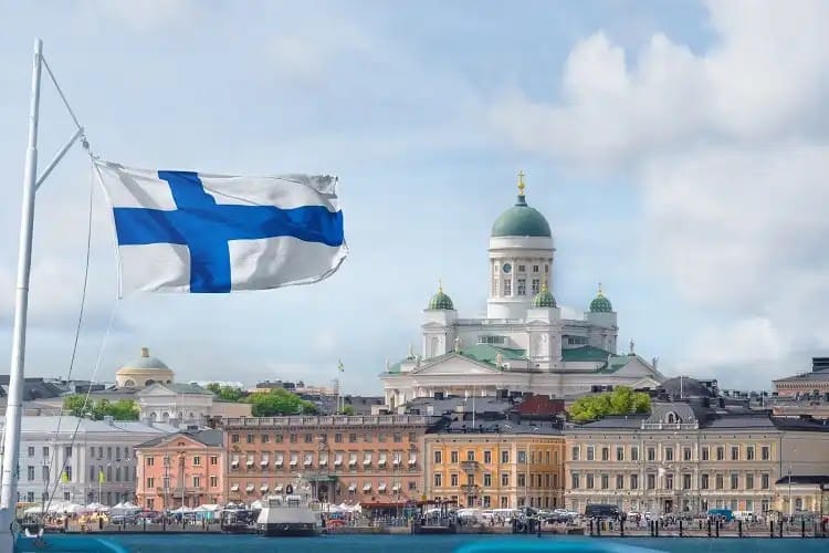 Bandeira da Finlândia tremulando, com a Catedral de Helsinque ao fundo