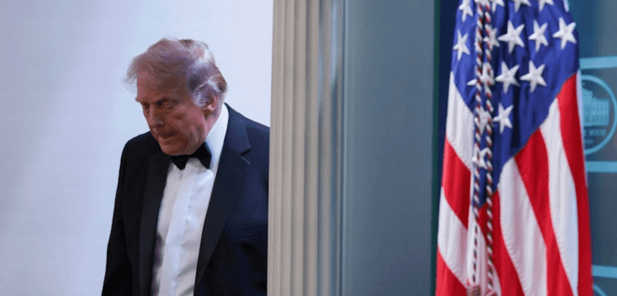 O presidente Donald Trump caminha ao lado de uma bandeira dos Estados Unidos, saindo de uma sala na Casa Branca