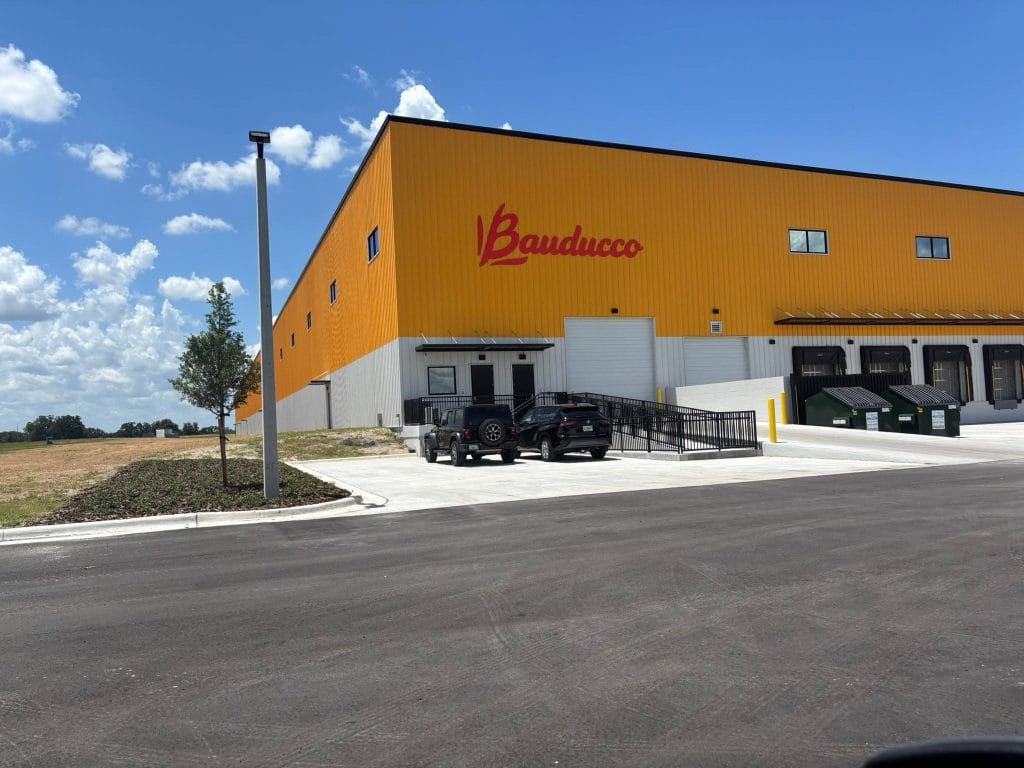 Fachada amarela da nova fábrica da Bauducco em Zephyrhills, na Flórida, com o logotipo em vermelho